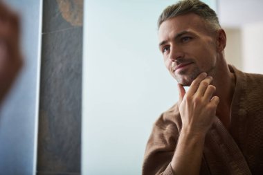 Çekici tıraşsız man aynaya evde banyo arıyorum