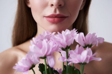 Dolgun dudaklar güzel pembe çiçek tutan genç kadınla