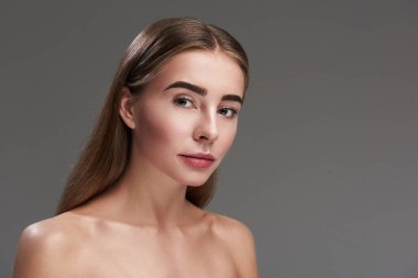 Güzel genç bayan gri arka planı ayakta