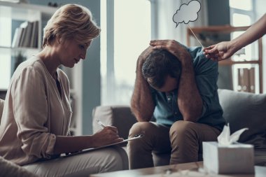 Depresif adam yüzünü ve notlar psikoterapist gizleme