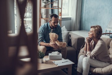 Adam oyuncak ayı hayret seyir ve psikoterapist sakin seyir