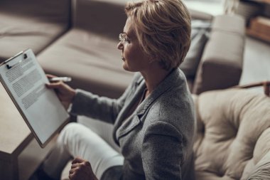 Düşünceli psikoterapist tek başına otururken onu notlar arıyorum