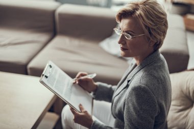 Düz arka oturma ve notlar tutarak kendine güvenen psikolog