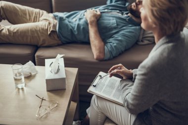 İstemci ile otururken notlar tutarak profesyonel psikoterapist