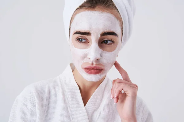Mérges lány kozmetikai maszk arc állt fehér háttér — Stock Fotó
