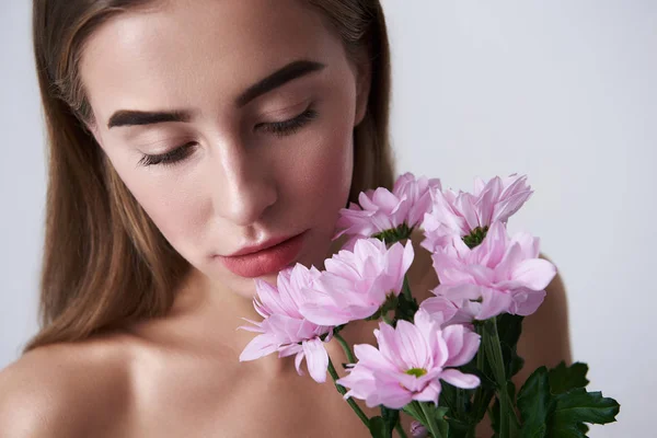 美しいピンクの花を持って魅力的な若い女性 — ストック写真