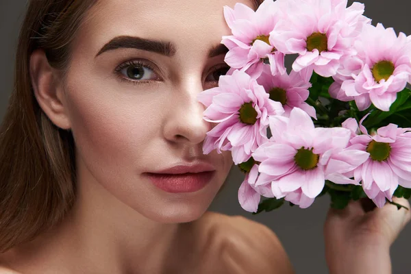 Красивая молодая женщина с красивыми розовыми цветами — стоковое фото