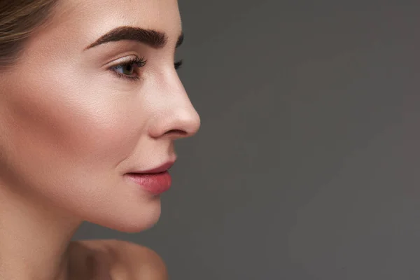 Attraktive junge Frau mit perfekter Haut isoliert auf grauem Hintergrund — Stockfoto