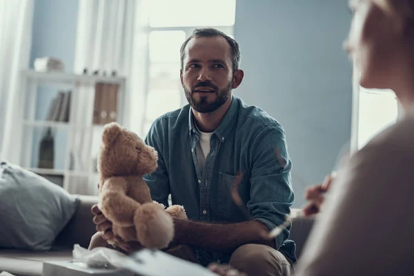 Oyuncak ayı tutarak onun psikoterapist bakan meraklı adam — Stok fotoğraf