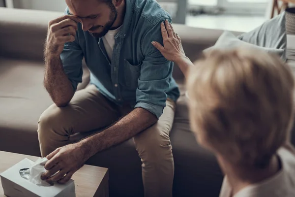 Freundlicher Psychologe, der dem Mann die Hand auf die Schulter legt — Stockfoto