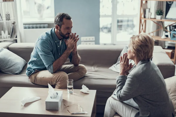 Zwei Erwachsene, die sich gegenübersitzen und die Finger an den Lippen haben — Stockfoto