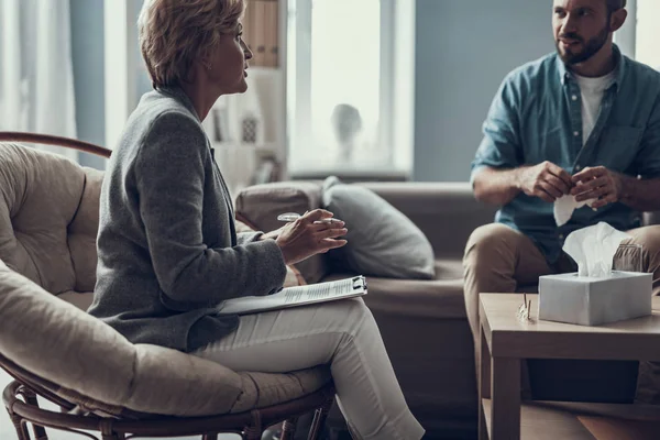 Bearded man holding paper tissue and his psychotherapist talking — Stock Photo, Image