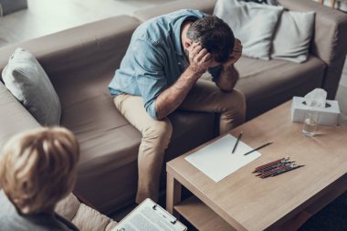 Psikolog ile Toplantı sırasında kafasına elleriyle oturan depresif adam