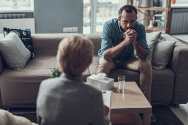 Ciddi adam çenesine elleri ve düşünme üzerinde koyarak