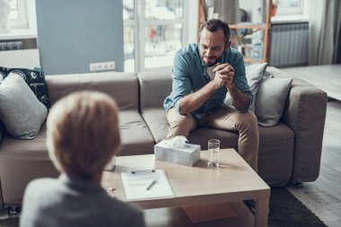 Gülümseyen ve onun psikiyatriste konuşurken sakallı adam