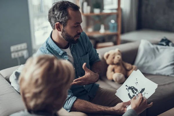 Hombre curioso discutiendo fotos de prueba con psicoterapeuta — Foto de Stock