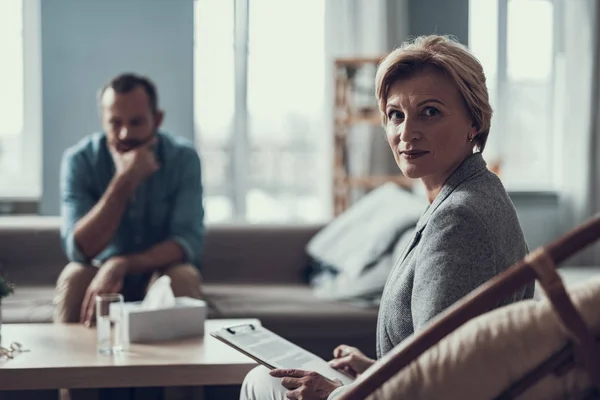 Selbstbewusster Psychotherapeut mit Notizen und Mann im Hintergrund — Stockfoto