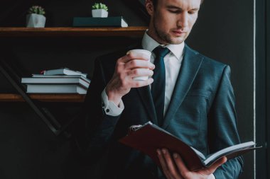 Çatık ve tek başına ayakta iken notlara bakarak genç girişimci