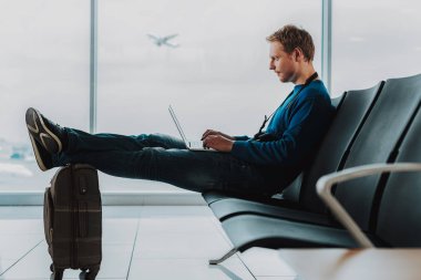 Ciddi adam uçuş önce laptop kullanıyor