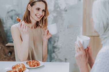 Neşeli kadın annesiyle buns ile çay içiyor