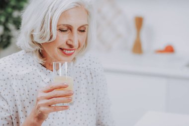 Rahat yaşlı kadın evde suyu içiyor