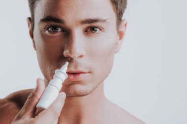 Genç adam burun damla kullanırken sakin seyir