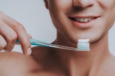 Diş fırçasının gülümseyen adam, elinde yakın çekim