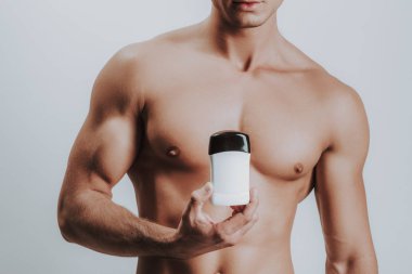 Kaslı çekici gömleksiz adam yeni deodorant gösteren