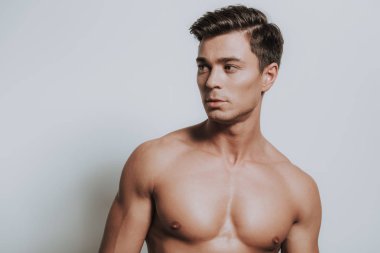 Gömleksiz eril genç adam kafasını sağa dönüm