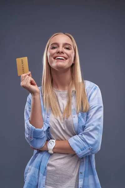 Glad ung dam i blå skjorta holding guldkort — Stockfoto