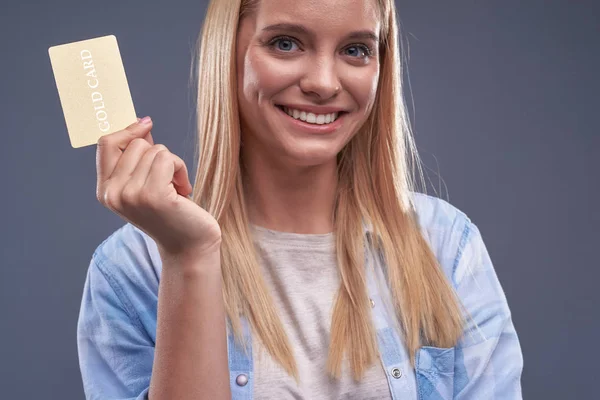 Atractiva joven mujer en camisa con tarjeta de oro — Foto de Stock