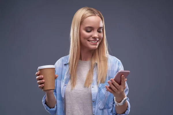 携帯電話を使用して温かい飲み物の魅力的な若い女性 — ストック写真