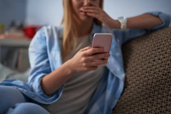 Mladá dáma v modré košili pomocí smartphone doma — Stock fotografie