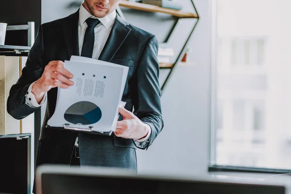 Nahaufnahme eines jungen Mannes, der steht und Diagramme betrachtet — Stockfoto