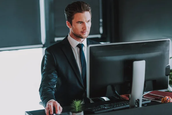 Hombre de negocios guapo trabajando en su computadora en la oficina —  Fotos de Stock