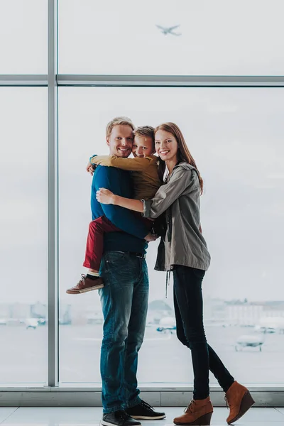 Familia alegre está abrazando antes de volar de vacaciones —  Fotos de Stock