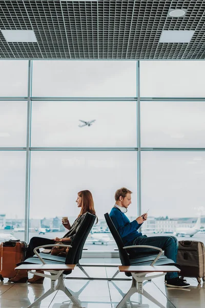 Чоловік і жінка проводять час в залі для аеропортів — стокове фото