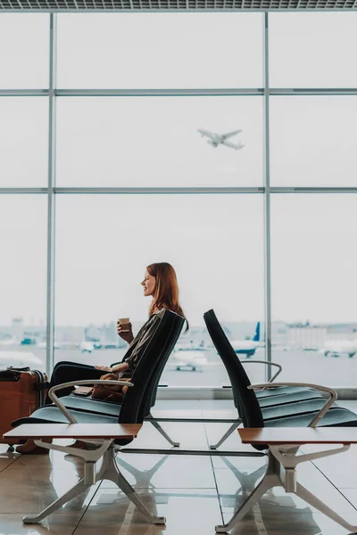 Señora emocionada se relaja con una taza de café en el aeropuerto — Foto de Stock