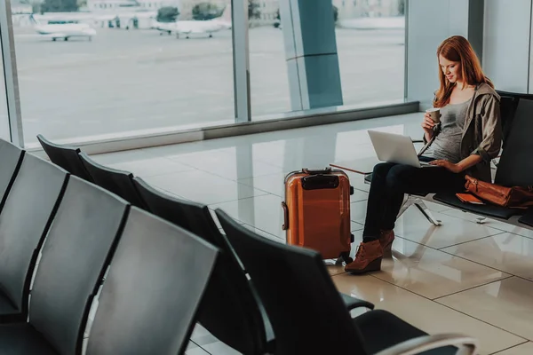 Spokojny kobieta używa laptopa przed lotem — Zdjęcie stockowe