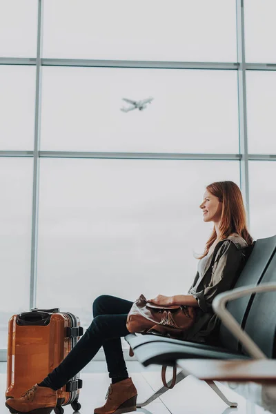 Vrolijk lachende vrouw is ontspannend op luchthaven — Stockfoto