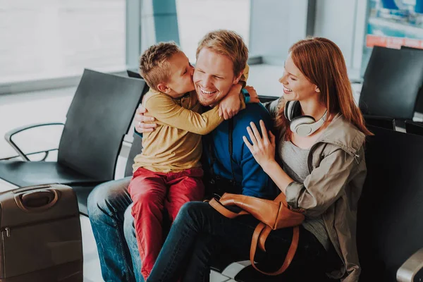 Família alegre está abraçando no lounge do aeroporto — Fotografia de Stock