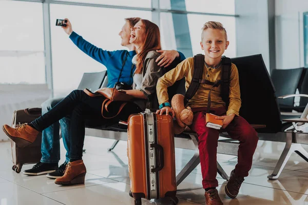 Sonriente chico es pasar tiempo con los padres en el aeropuerto —  Fotos de Stock