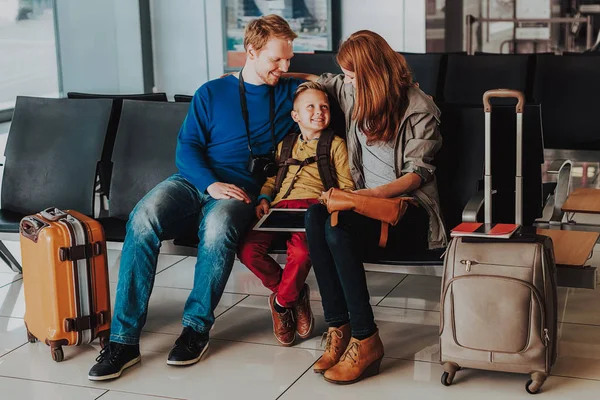 Lättsam familjen spenderar tid med gadget på flygplats — Stockfoto