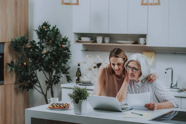 Gelukkig jonge dame is tijd doorbrengen met laptop en moeder — Stockfoto