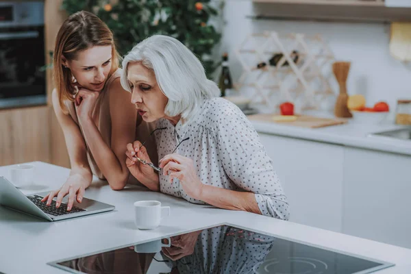 Mujer joven y madre están pasando tiempo con el ordenador portátil de interior —  Fotos de Stock