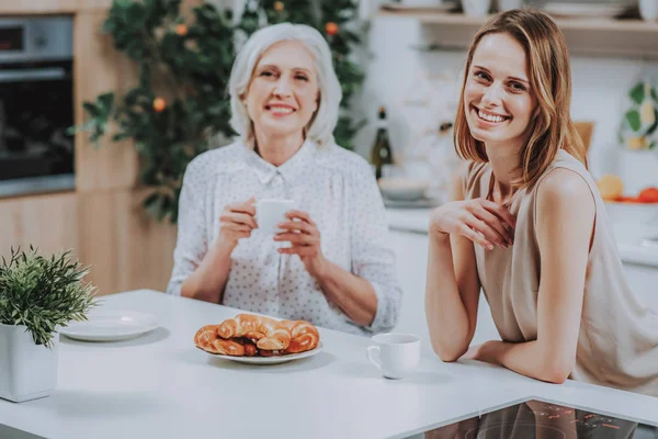 Mujer alegre está bebiendo café con mamá en la cocina —  Fotos de Stock