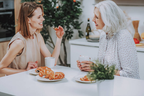 Счастливые женщины общаются за чашкой чая дома
