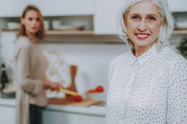 Alegre mujer madura es pasar tiempo con su hija en la cocina —  Fotos de Stock