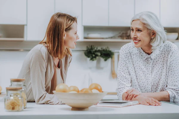 La madre y la hija positivas se comunican en la acogedora cocina —  Fotos de Stock