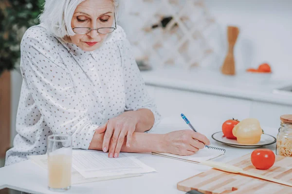 Mature woman is creating food recipes at home